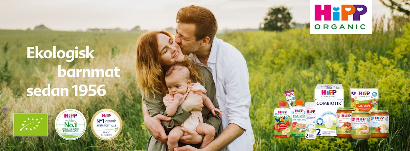 Leende familj med mamma, pappa och bebis i en grön äng, omgiven av HiPP Organic barnmatsprodukter och texten "Ekologisk barnmat sedan 1956".