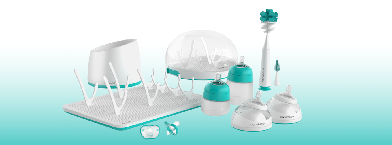 Flera babyprodukter från Nanobébé, inklusive flaskor, nappflaskborste, torkställ, nappar och sterilisator, arrangerade på rad.