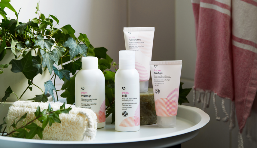 På ett bord i ett badrum står produkter från Apotek Hjärtats intimvårdsserie uppradade.